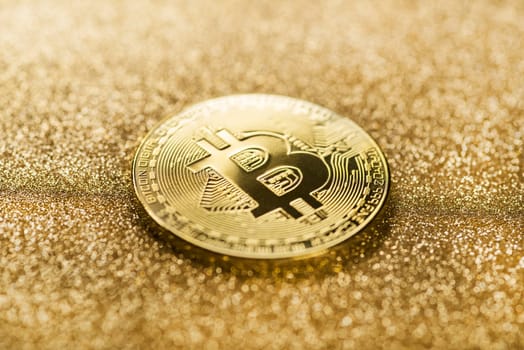 Bitcoin gold coin on a gold shining background..