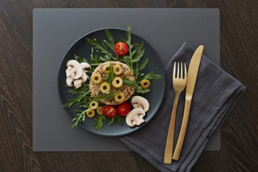 Healthy quinoa dish. Dietary salad with quinoa, mushrooms, arugula and olives. Healthy food, vegetarian menu. Top view. Setting table.