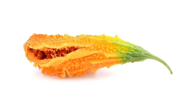 Ripe bitter melon with orange flesh, splitting open to show sticky red seeds, isolated on a white background