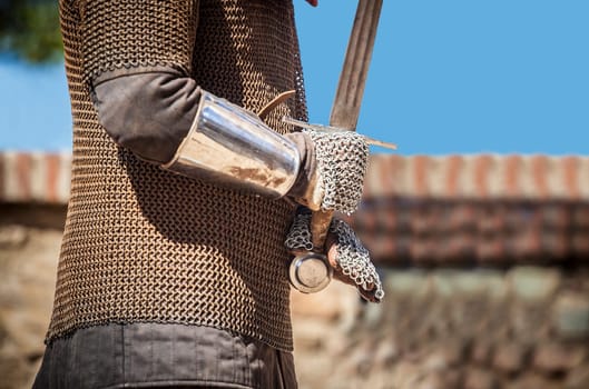 Reconquest warrior covered with chain mail mittens or muffs. He is gripping the sword