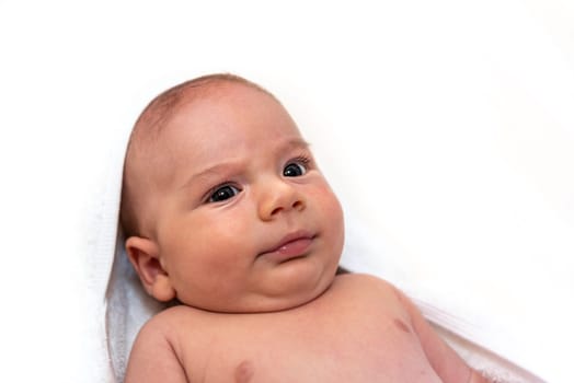Adorable 2 months old little baby boy on towel after bath over white background