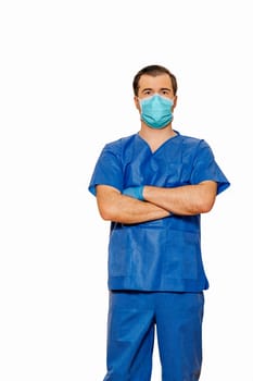 Male doctor in scrubs wearing protective face mask and gloves with cross hands waiting for patients. Plain white background Coronavirus concept