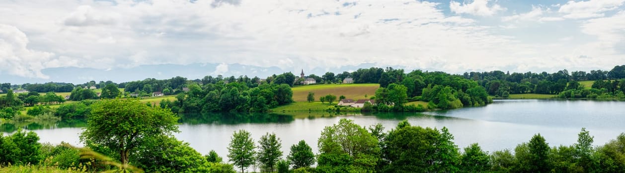 a village, small church, lake and french pyrenees mountains background