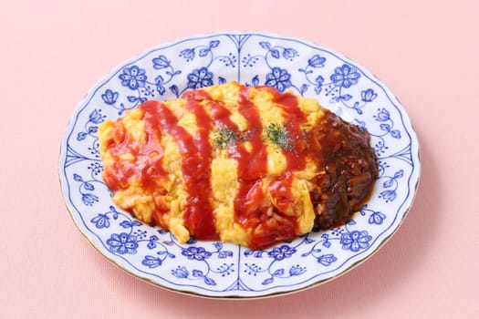 Japanese food, Omuraisu with ketchup in a plate on table