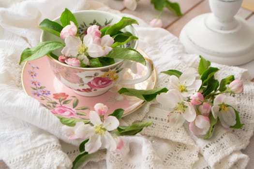 handmade lace on shabby chic and pink retro mug with white flowers. Macrame closeup. Wedding or holiday background.