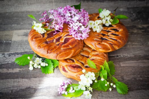 Strawberries and blackcurrant pie or buns with jam, decorated with spring flowers