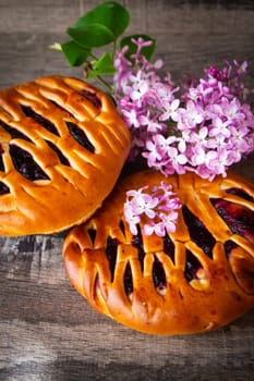 Brioche dough with blackcurrant, with violet lilac flowers, vertical image
