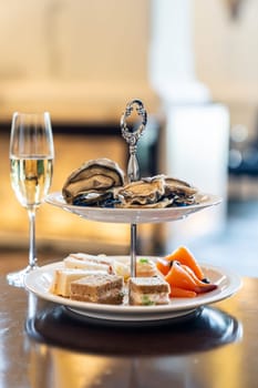 Welcome cocktail Canapes dish, Fresh Oyster and smoked salmon seafood dish with sparkling champagne. Appetizer dish before groumet brunch buffet international cuisine.