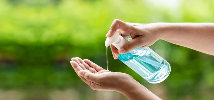 Panorama cleaning hand using alocohol gel waterless in pump bottle, disinfection for safety prevent and protect from virus Covid-19 coronavirus infection world pandemic. Panoramic web banner crop.