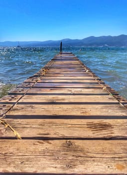 Wooden pier by the sea. Boards of the pier and sea waves.