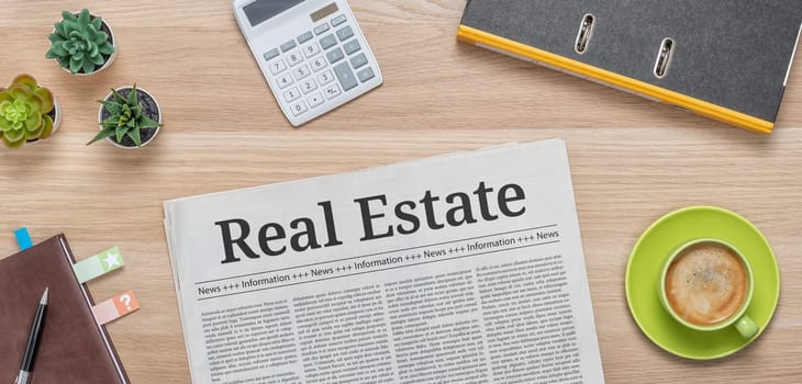 A newspaper on a desk with the headline Real Estate