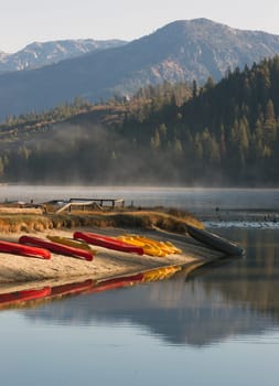 The early morning mist has yet to burn of the lakes surface of this mountain lake