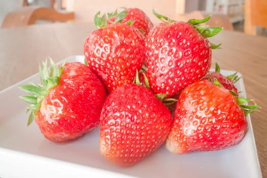 Fresh ripe strawberries on white plate, stock photo