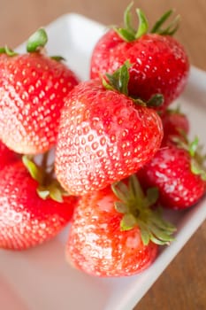 Fresh ripe strawberries on white plate, stock photo