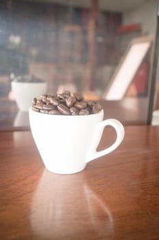 Roast coffee bean in white mug, stock photo