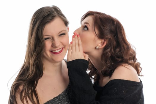 Girl whispers something in her friend's ear