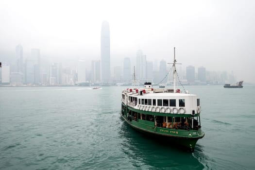 A ferry in Hong Kong harbour with the city skyline in the background