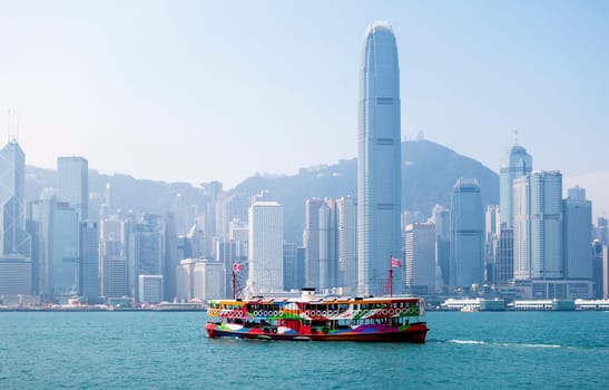 A ferry in Hong Kong harbour with the city skyline in the background