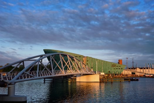 AMSTERDAM, NETHERLANDS - MAY 9, 2017: NEMO Science museum and Mr. J.J. van der Veldebrug bridge. It is the largest science center in Netherlands with over 500000 visitors per year