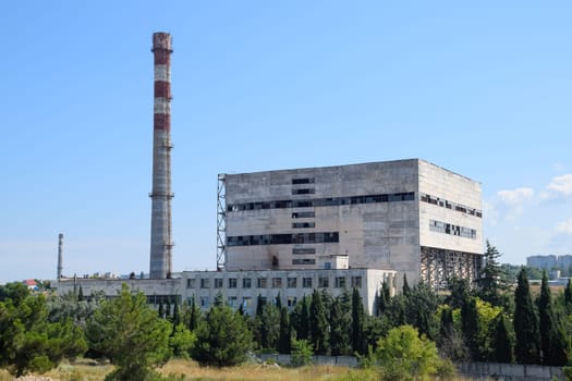 An old Soviet factory with a pipe. Abandoned Soviet industry.