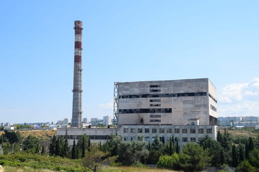 An old Soviet factory with a pipe. Abandoned Soviet industry.