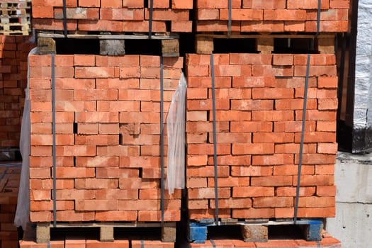 Bricks on pallets. Storage of bricks at the construction site.
