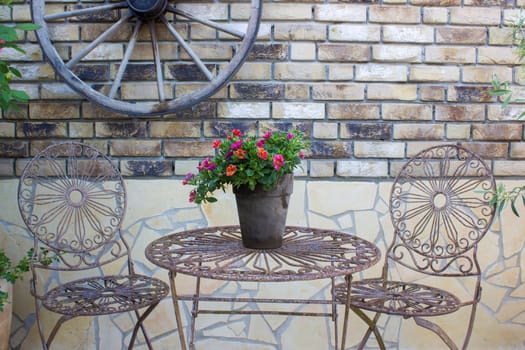 beautiful place in the garden in the mediterranean style, pot with petunia on the table