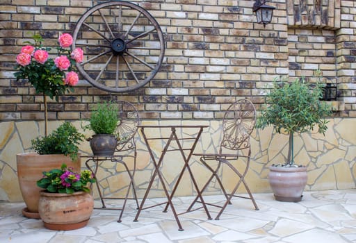 beautiful place in the garden in the mediterranean style, brick wall with grill and pots with flowers