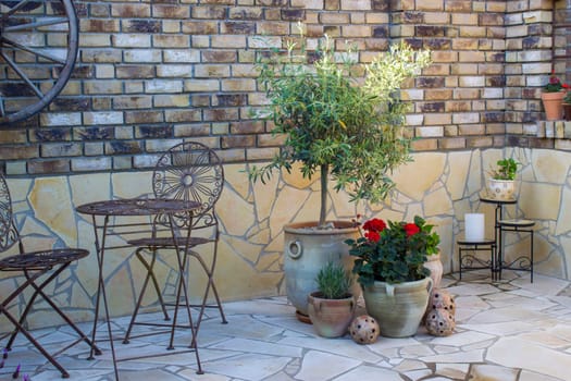 beautiful place in the garden in the mediterranean style, brick wall with grill and pots with flowers