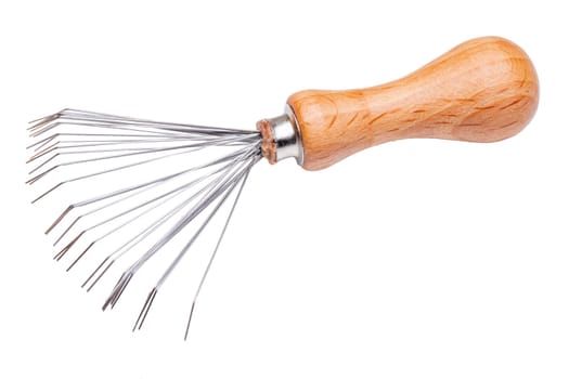Closeup of a brush and comb cleaner with wooden handle and metal brushes. A very practical tool for removing hairs that have got stuck in the hairbrush or comb. Macro.