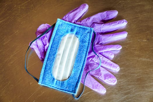 Top view of N-95 mask and nitrile disposable gloves on a steel surface