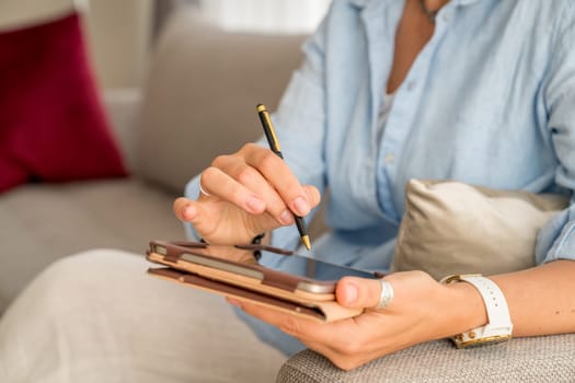Close-up of woman's hands holding tablet PC and a stylus pen
