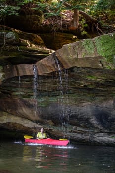 Kayaker behind a small waterfall on Grayson Lake in Kentucky