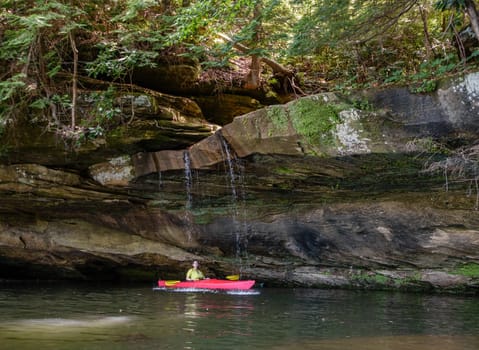 Kayaker behind a small waterfall on Grayson Lake in Kentucky