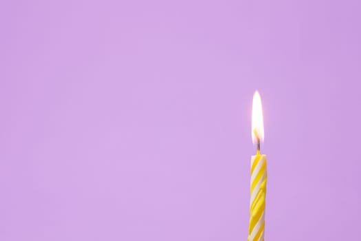 One festive candle is lit, light purple background