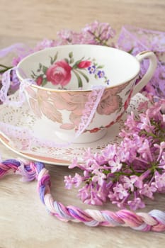 Lilac flowers with vintage cup, violet and purple colors, vertical image
