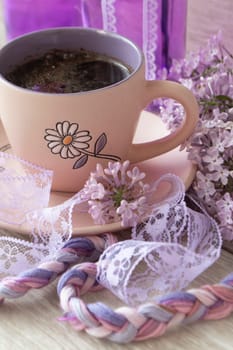 Branches and flowers of lilac with purple petals. Cup with coffee, cocoa, spring breakfast. Vintage, vertical image