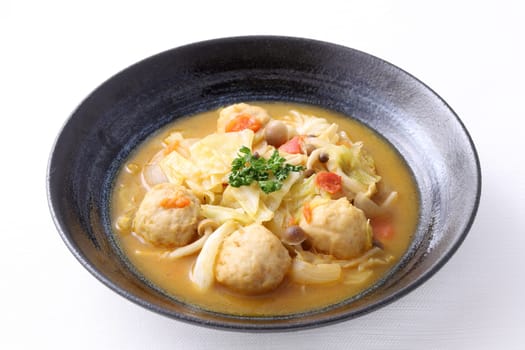 meat ball with vegetable soup in a dish on white background