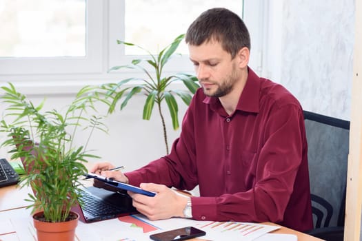 office employee works on a tablet in a light office