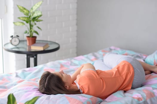 Girl sleeps in bed on the background of a window