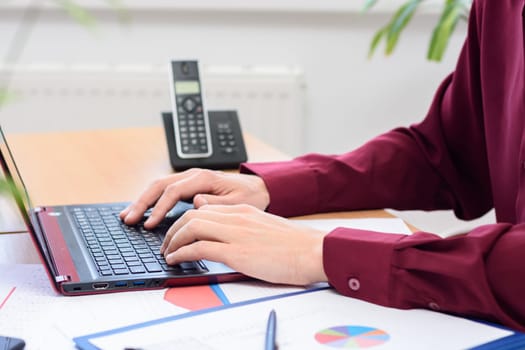 close-up of the hands of an office employee working on a laptop