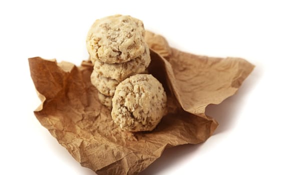 Shortbread with nuts and seeds in craft paper. Isolated on a white background close up