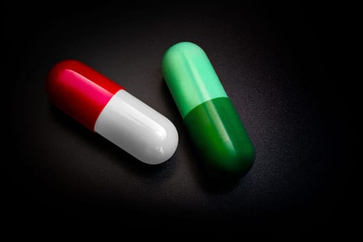 Two capsules therapy doctor flu antibiotic pharmacy medicine medical. Isolated on black background