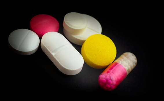 Diferent Tablets mix heap drugs pills capsules therapy doctor flu antibiotic pharmacy medicine medical on black background
