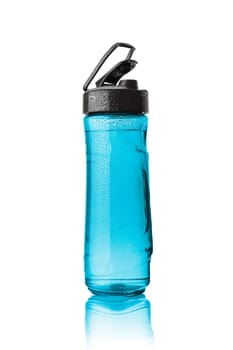 Plastic blue sports bottle is covered with droplets. Isolated on white background.