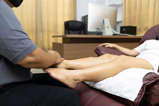 Quarantine asian woman do foot massage at home while city lockdown for social distance due to coronavirus pandemic. Massage and spa is one of service business that shutdown while city lockdown.