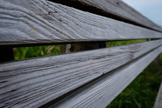 Weathered wood of a bench backrest close-up