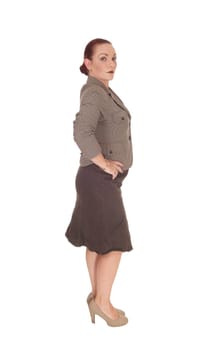 A pretty business woman standing full length in the studio and looking.into the camera, isolated for white background.