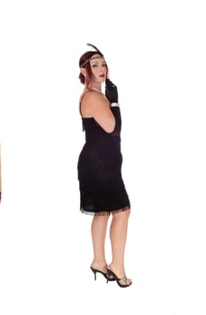 A beautiful woman standing in a black dress in profile with her .red hair and head band and cloves, isolated for white background.