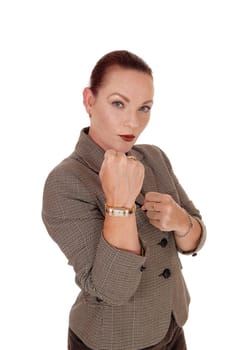 A middle age businesswoman standing and punching with her fist.is very angry, isolated for white background.